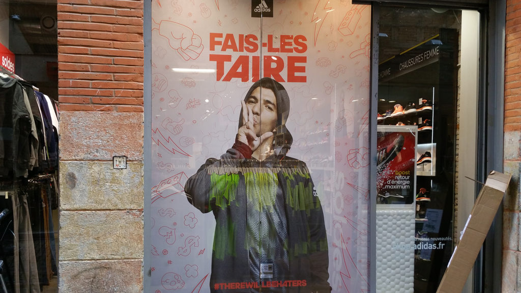 Vitrine de magasin à Toulouse habillée d’un adhésif publicitaire grand format posé par MZS Design