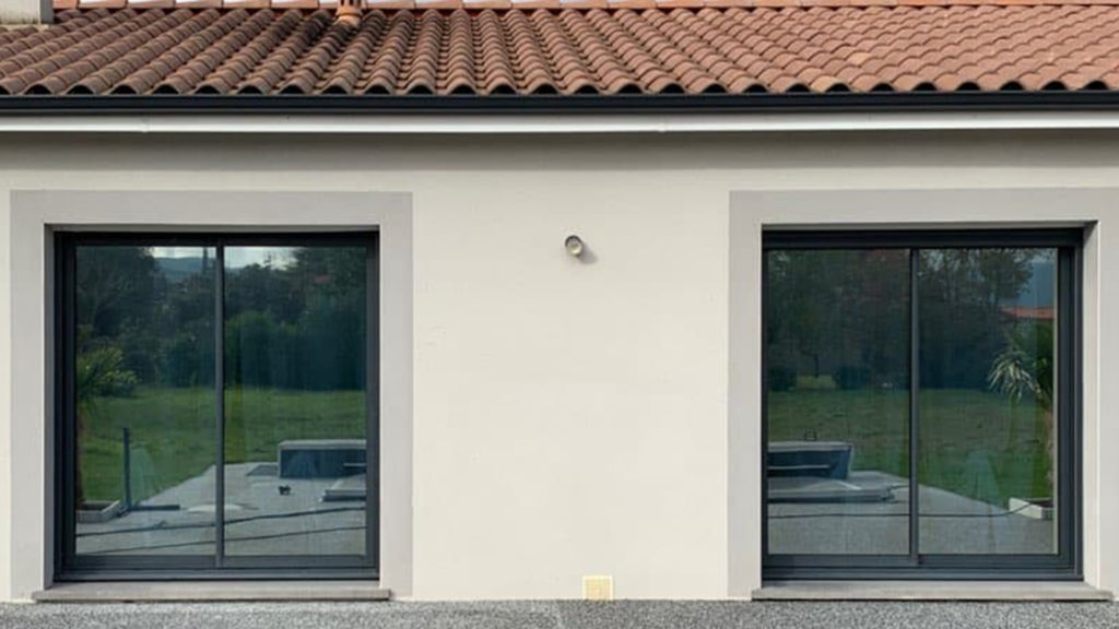 Maison avec deux baies vitrées équipées d’un film solaire miroir