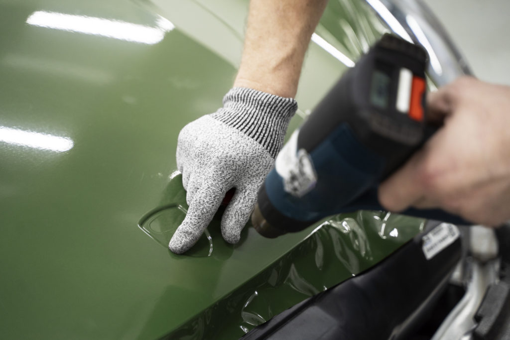 Technicien du réseau MZS Design posant un film de covering sur une voiture